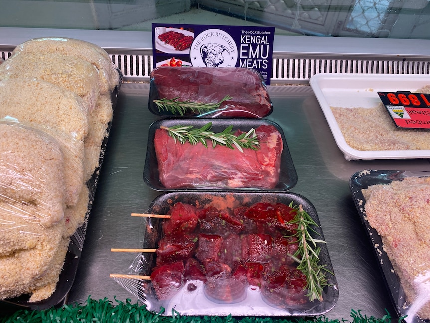 Emu meat in trays surrounded by schnitzel in a butchery display cabinet. 