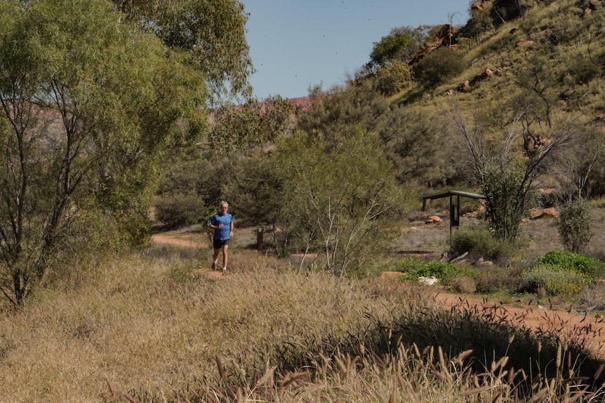 A man runs down a bush path in Alice Springs.