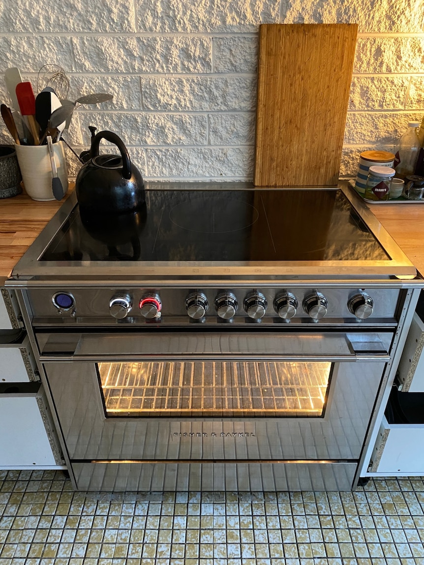 A large domestic oven with a smooth black induction cooktop.