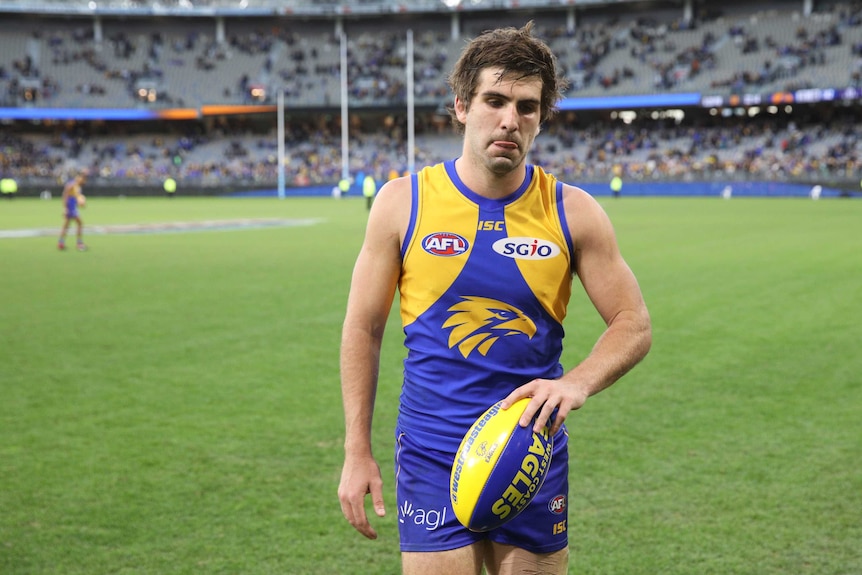 Andrew Gaff holds a football and looks disappointed after the game.