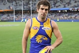 Andrew Gaff holds a football and looks disappointed after the game.