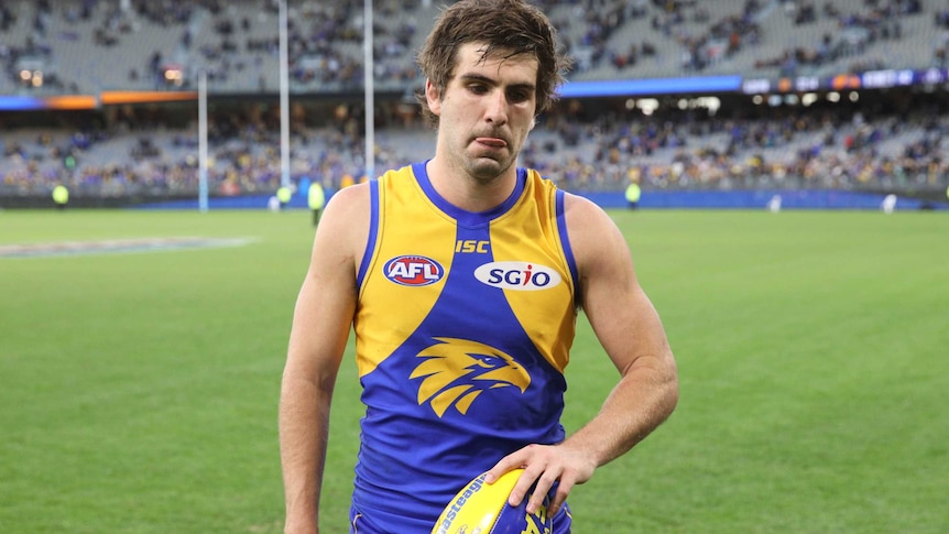 Andrew Gaff holds a football and looks disappointed after the game.