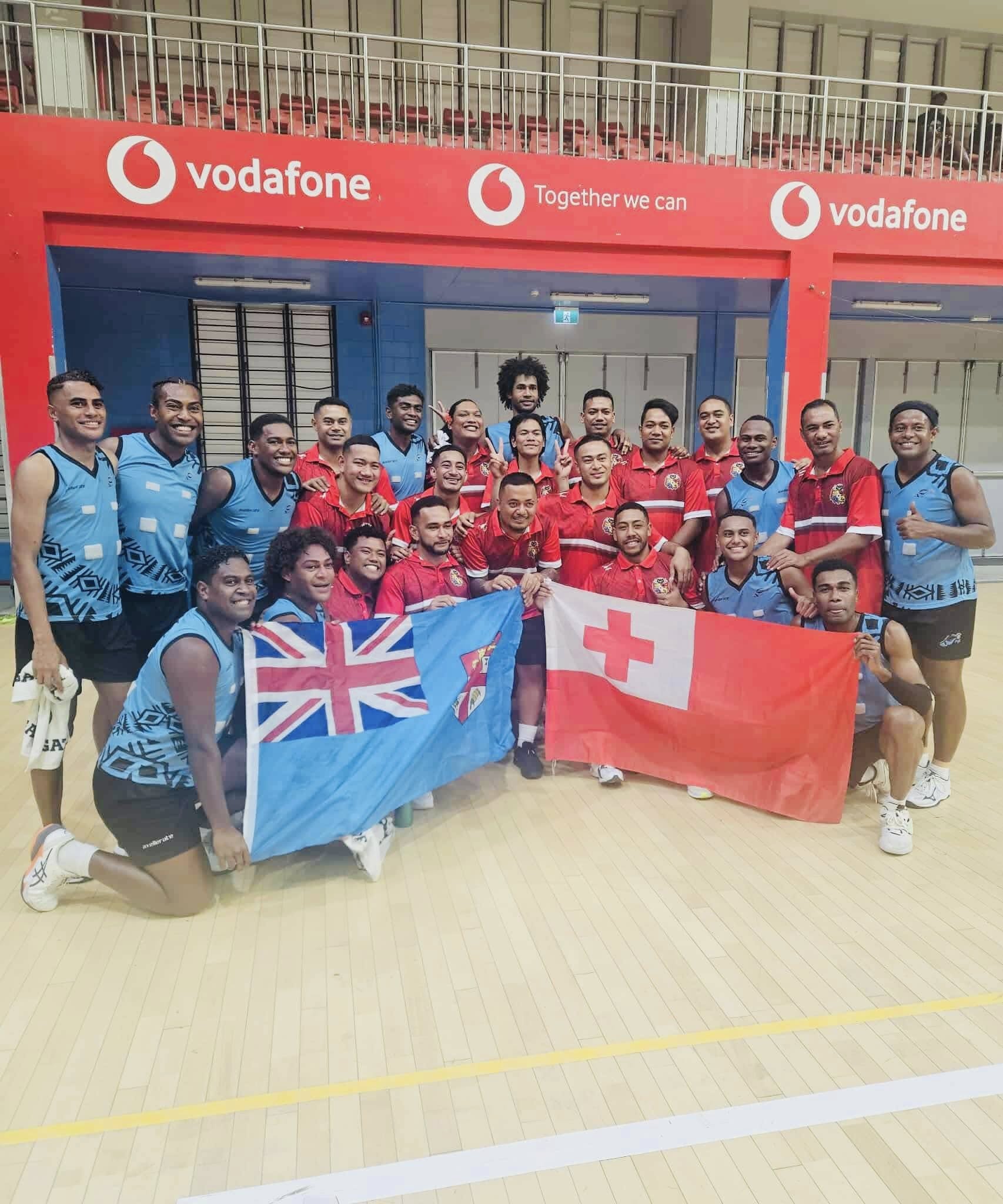 The Tongan and Fiji netball teams pose for a photo together.