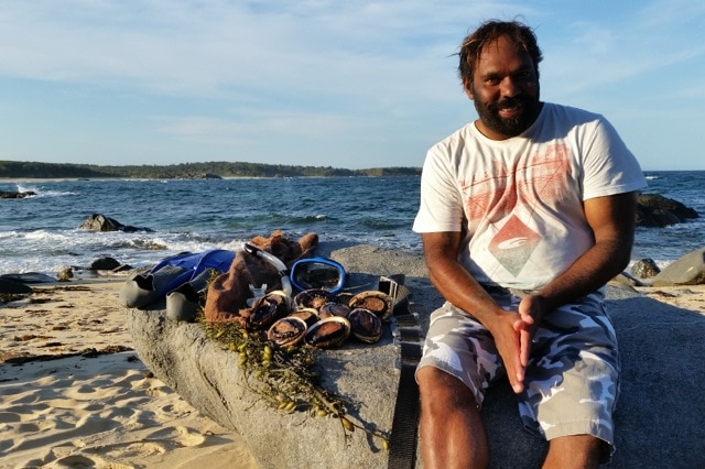 Wayne Carberry sits next to abalone he collected in waters off the NSW south coast.