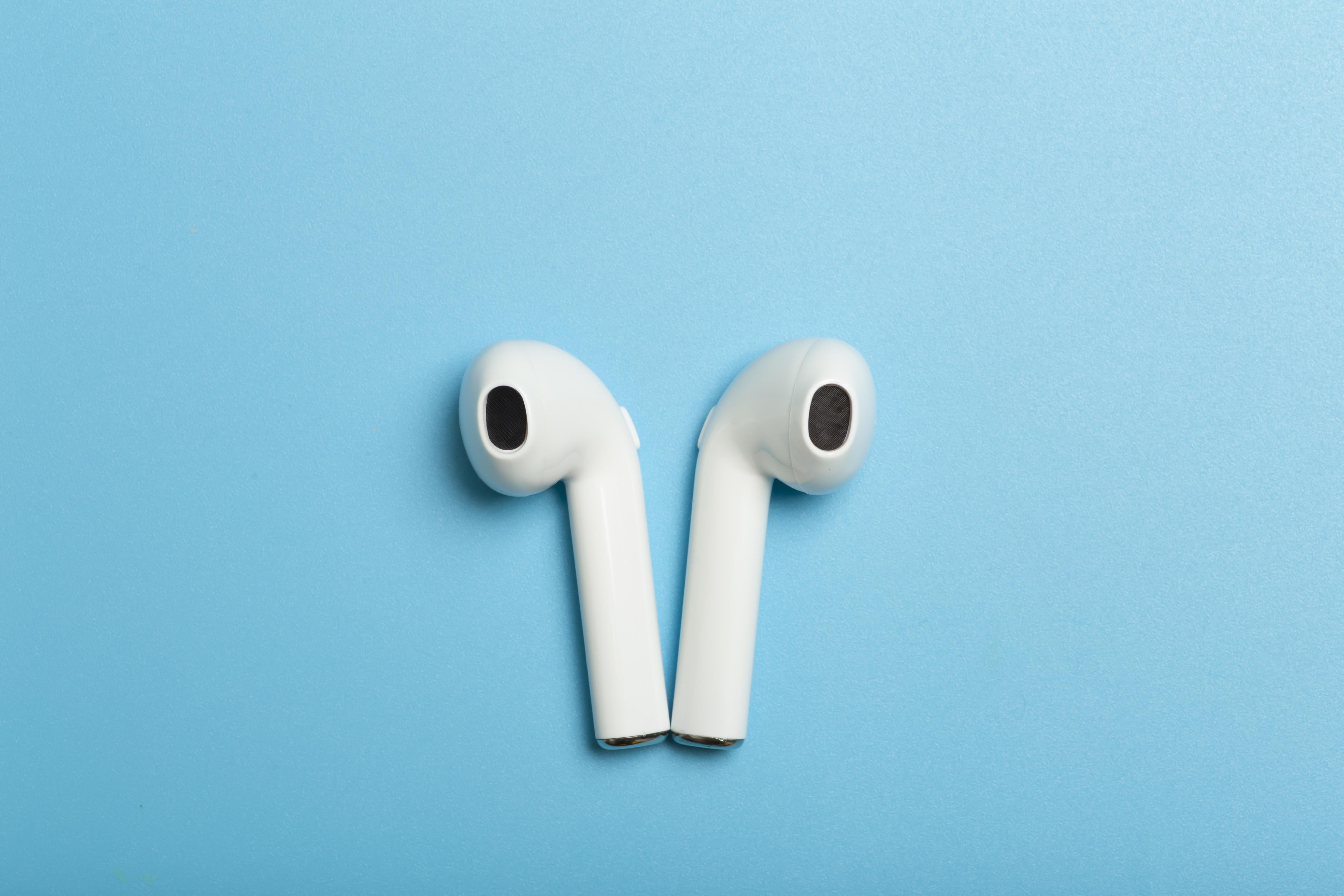 Close-up of in-ear headphones against a blue background