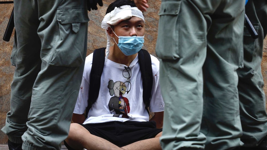 周三，一名示威者在香港中环地区被防暴警察包围。
