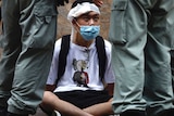 周三，一名示威者在香港中环地区被防暴警察包围。