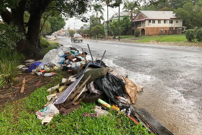 pile of rubbish on side of a wet road