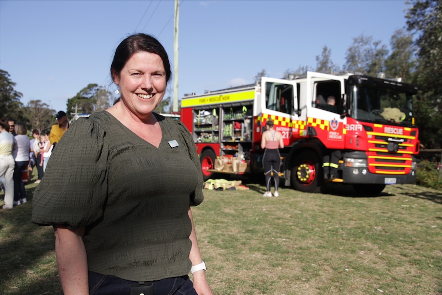 A woman standing next to a fire truck.