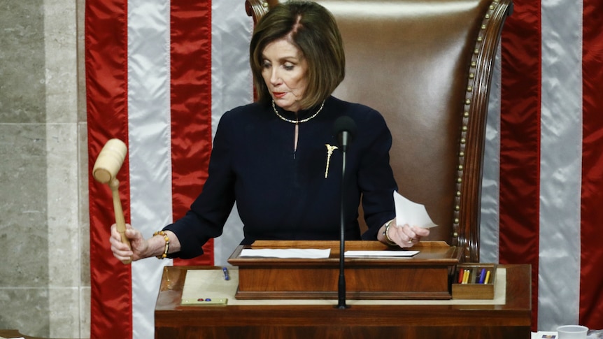 House Speaker Nancy Pelosi strikes the gavel after announcing the passage of article II of impeachment.
