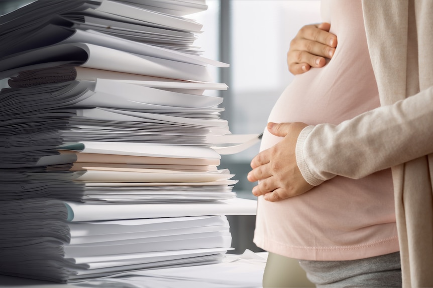 A pregnant woman faces a pile of documents
