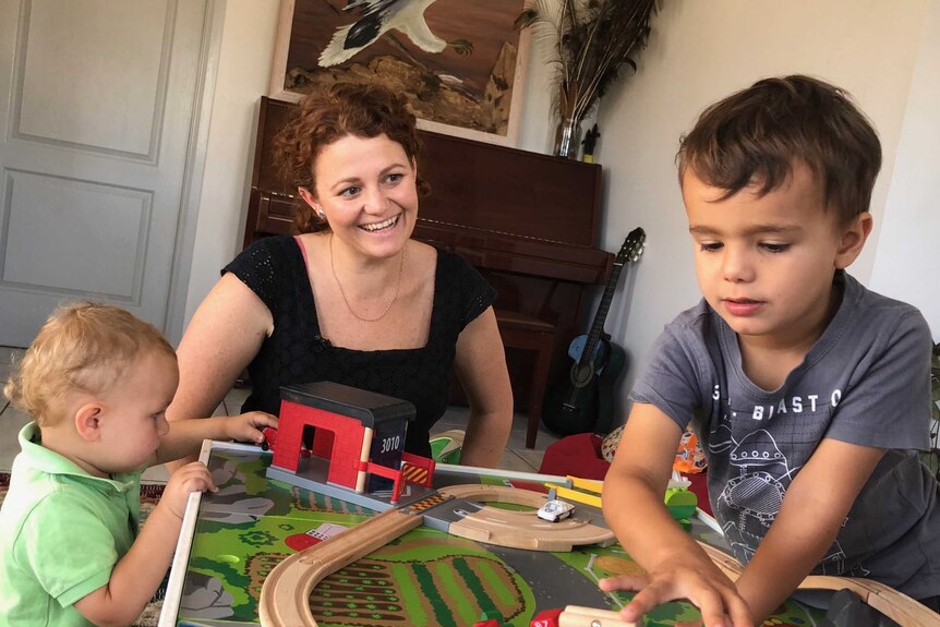 Mum Lucy Ford plays with a train set with her two children.