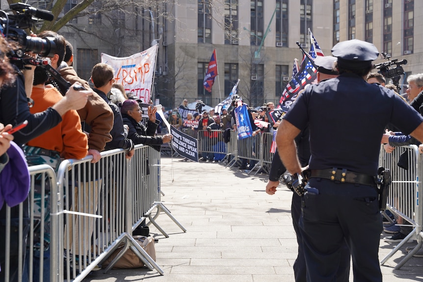 Lines of protesters separated by a fence.