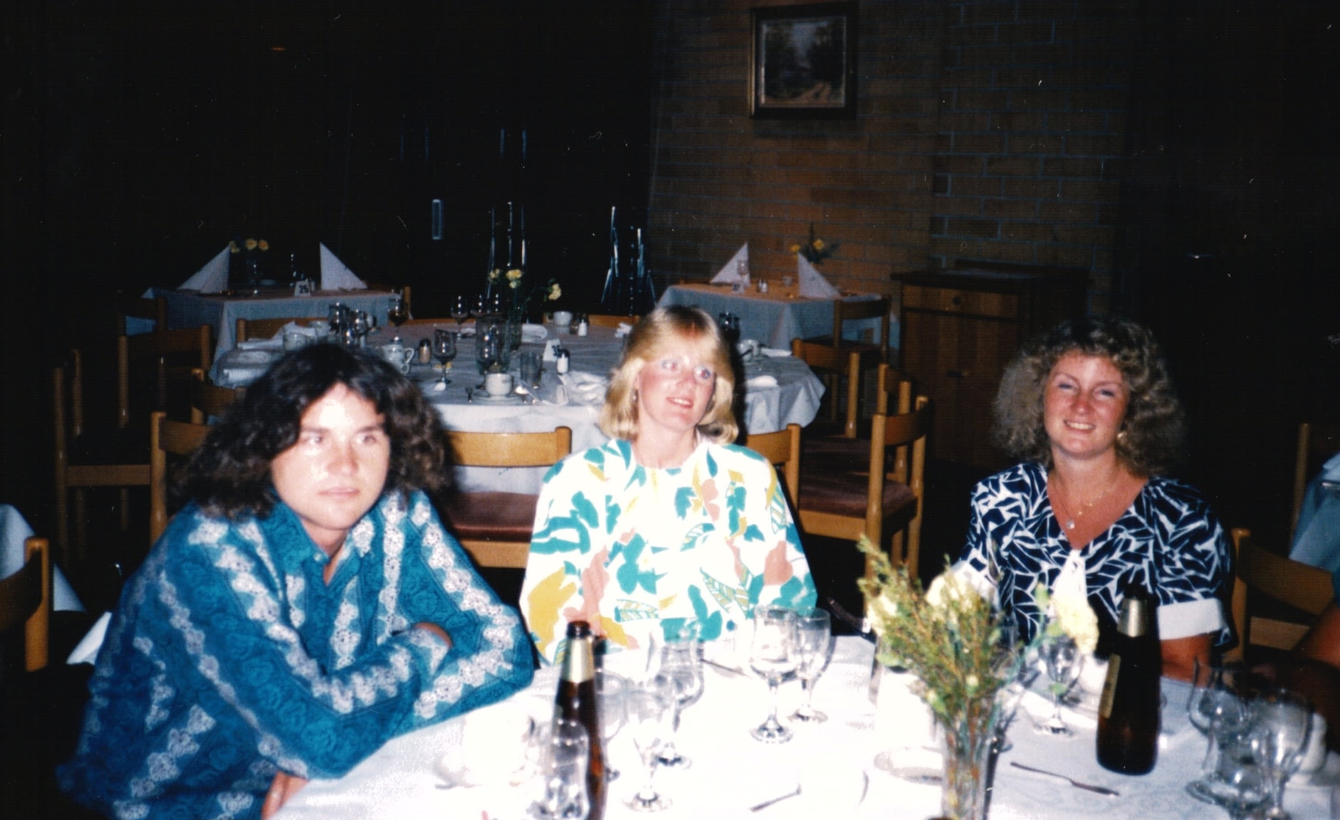 Two women and a man sit at a table.
