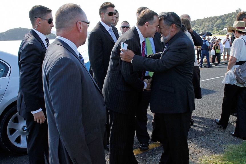 New Zealand prime minister john key touches his head together with pita sharples.