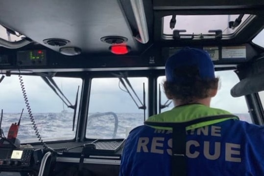 A photo from within a marine rescue boat while its at sea with a boat in the water.