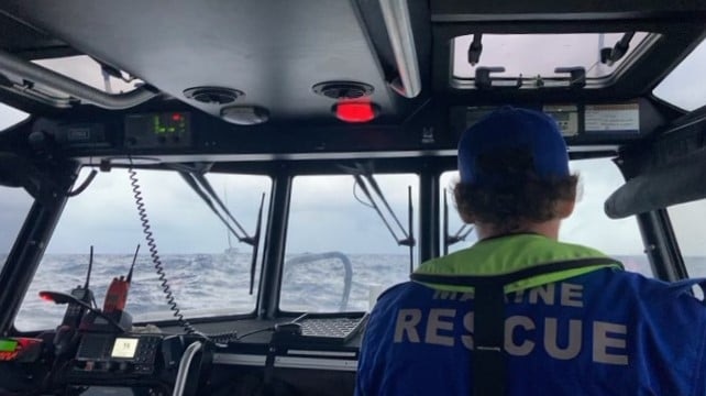 A photo from within a marine rescue boat while its at sea with a boat in the water.