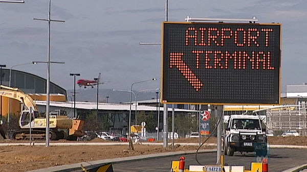 A plane lands at Canberra Airport behind road construction