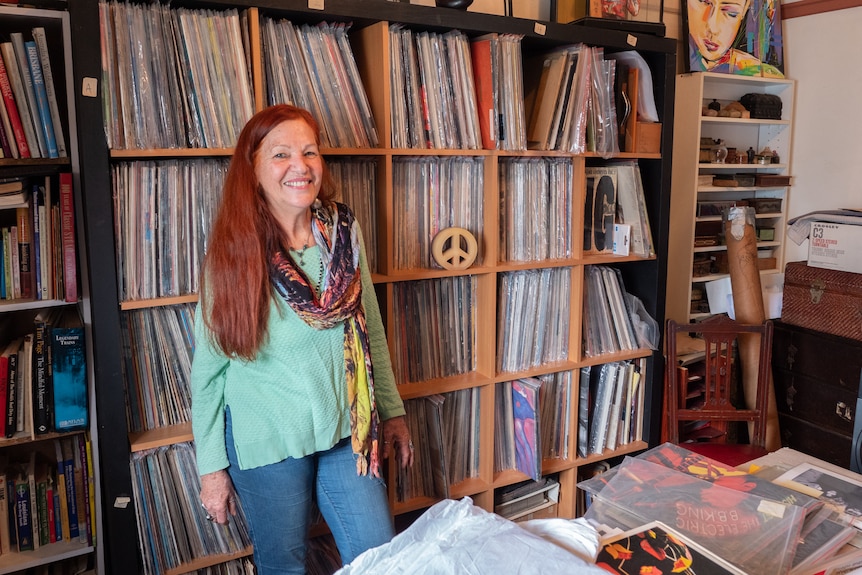 Minnie Yorke surrounded by walls of vinyl and music memorabilia.