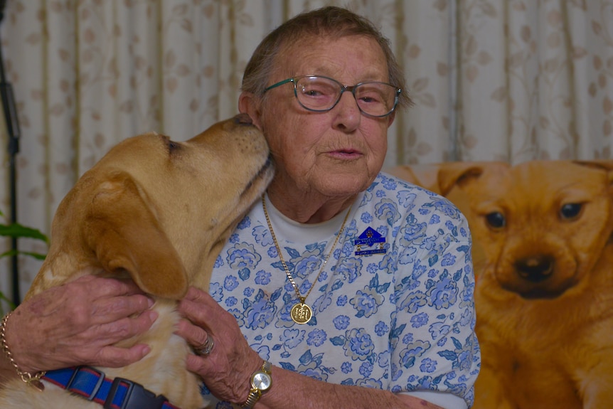 Claire Donovan receives a kiss on the cheek from a retired guide dog.