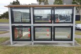 A glass bus shelter with solar panels
