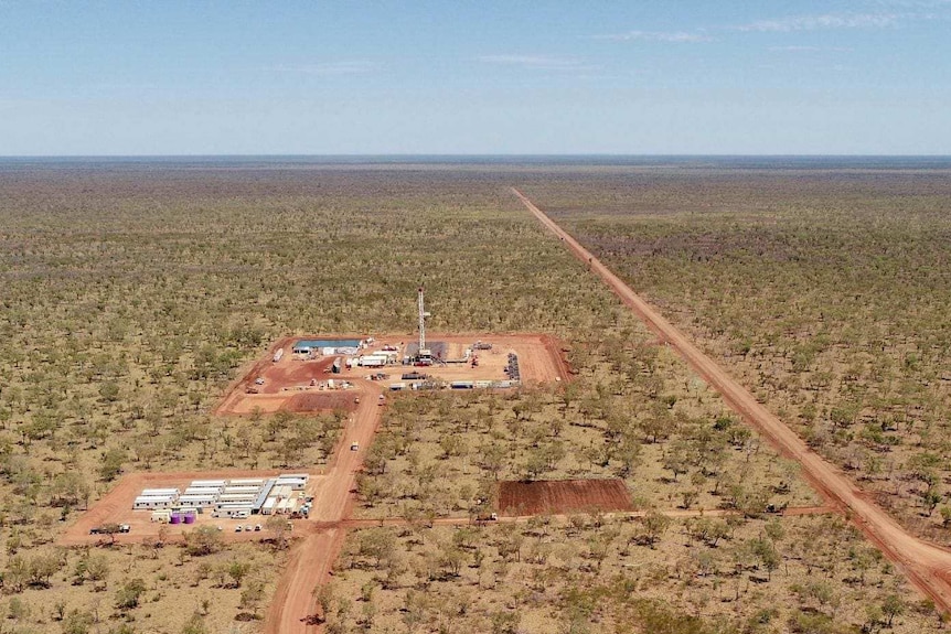 A gas development in the middle of a land clearance in the Beetaloo Basin, surrounded by trees.