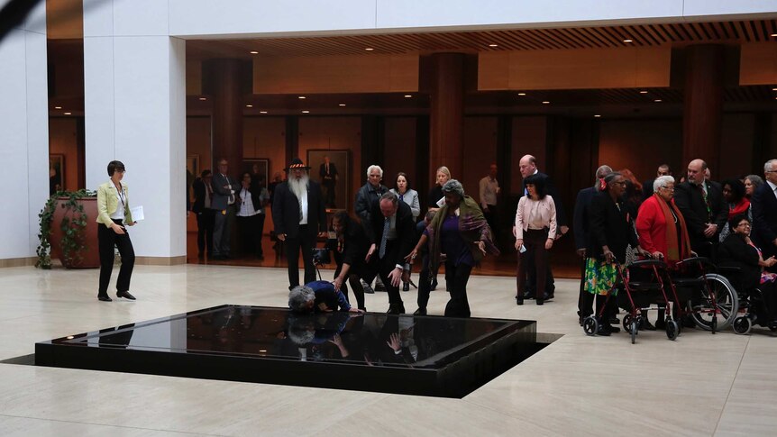 Barnaby Joyce and others reach to grab a woman falling into a fountain at Parliament House on May 24, 2017.
