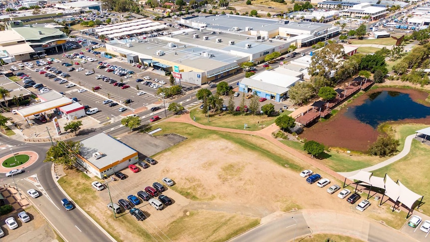 An aerial view of cars and buildings and parkland in Pialba.