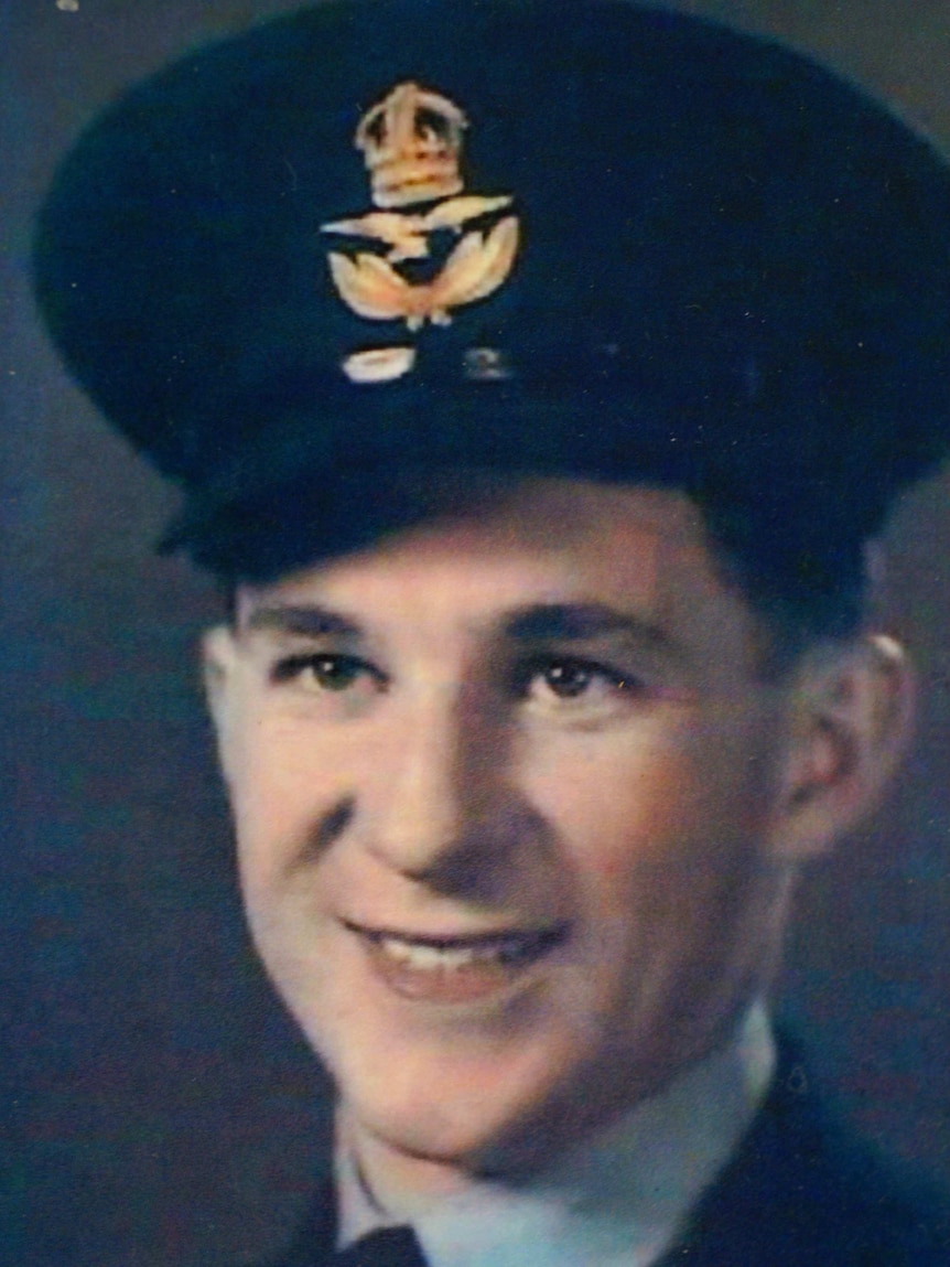 A headshot of a young smiling man in a military uniform.