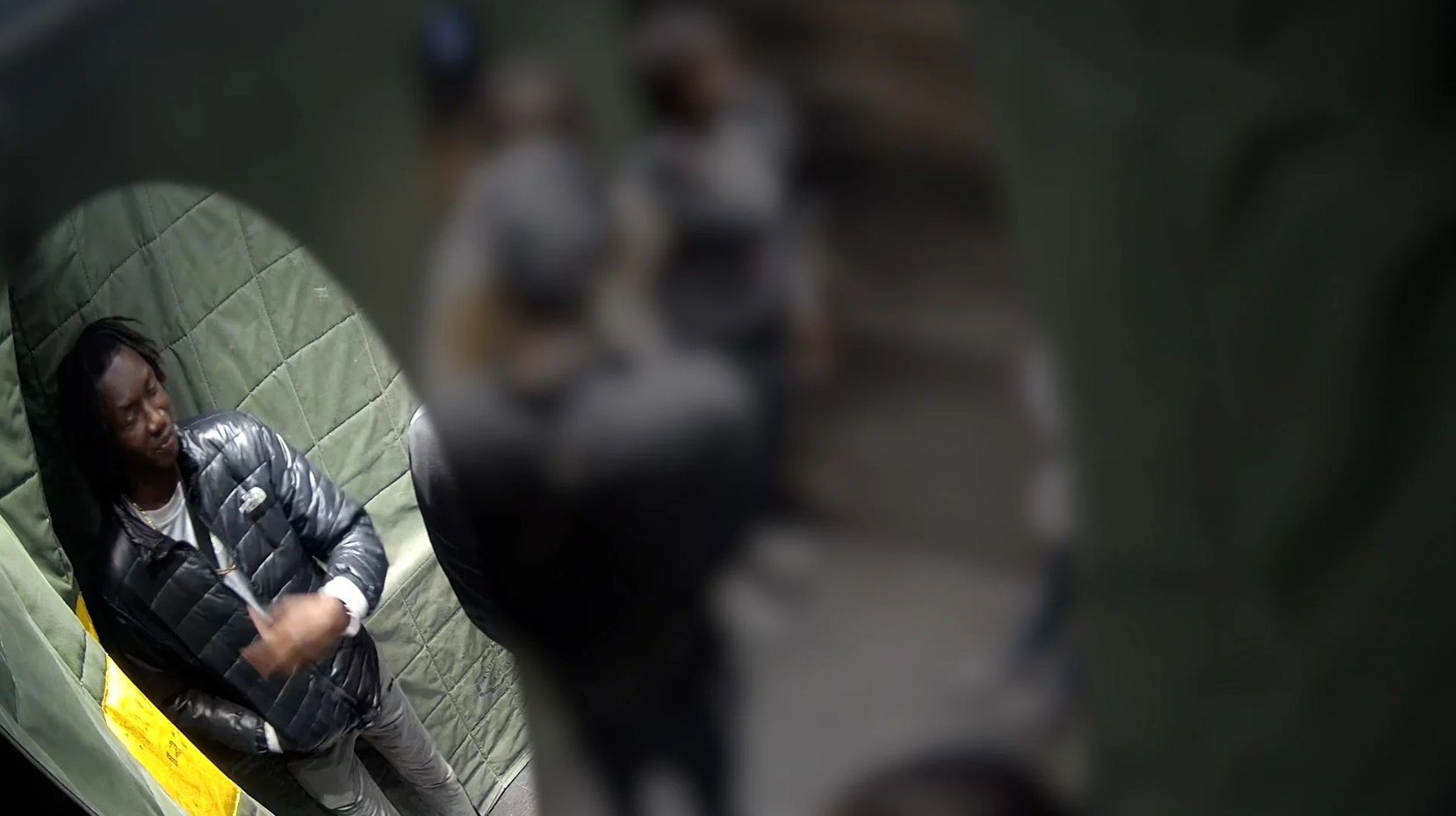 a man in a puffer jacket shown on CCTV footage