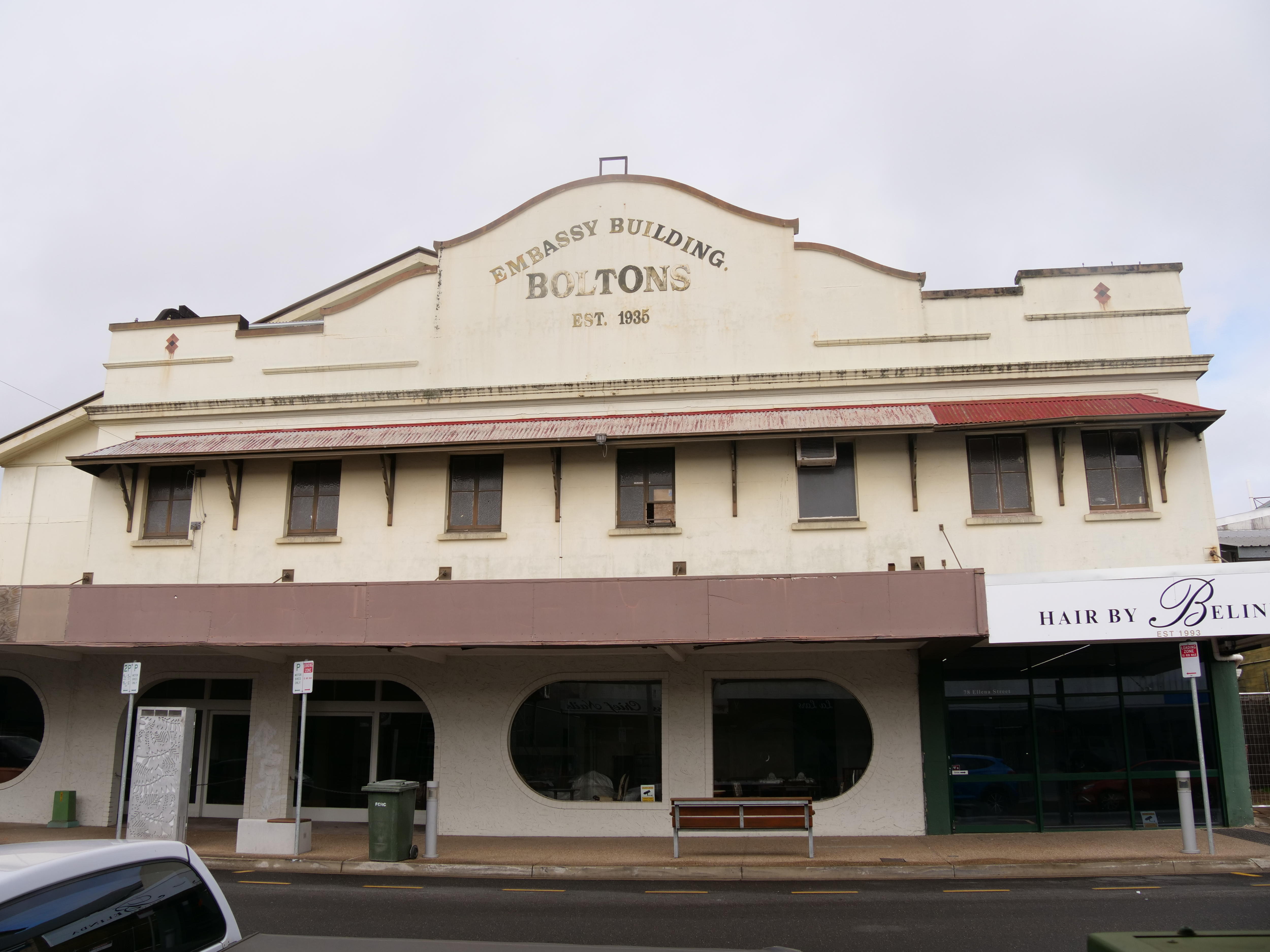 A medium-sized yellow building with the words 'Embassy Theatre' written in gold block letters on the top.