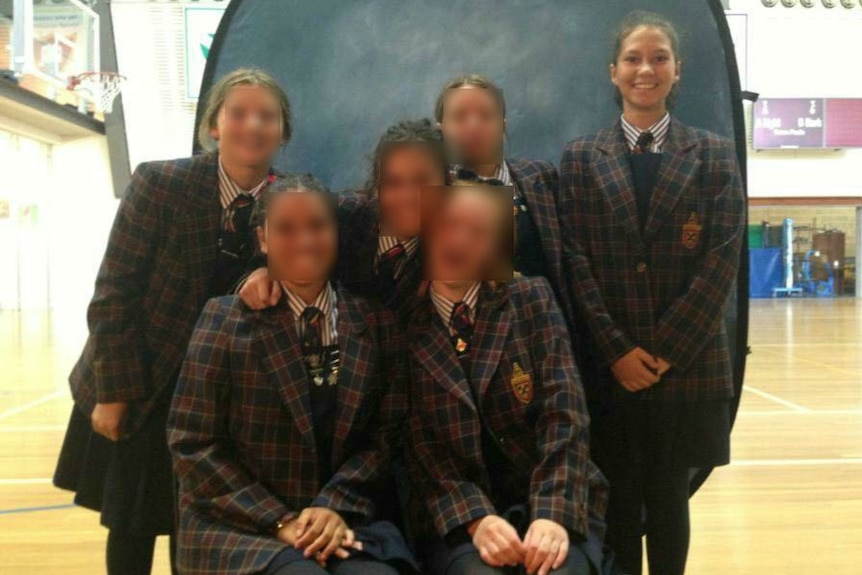 Six schoolgirls pose for a class photo.