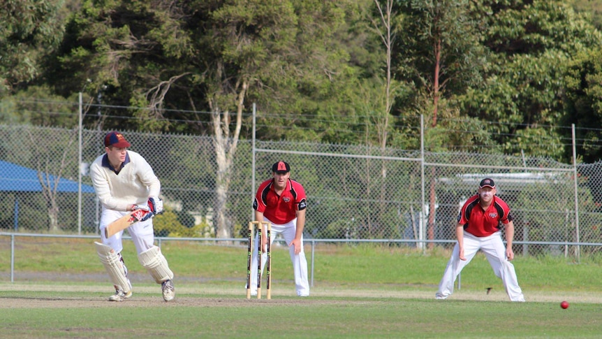 A batter plays the ball on the leg side as the wicket keeper and slips fielder watch on