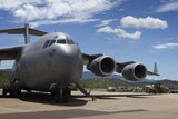 A Royal Australian Air Force (RAAF) C-17 Globemaster plane appears on a runway in a stock image.