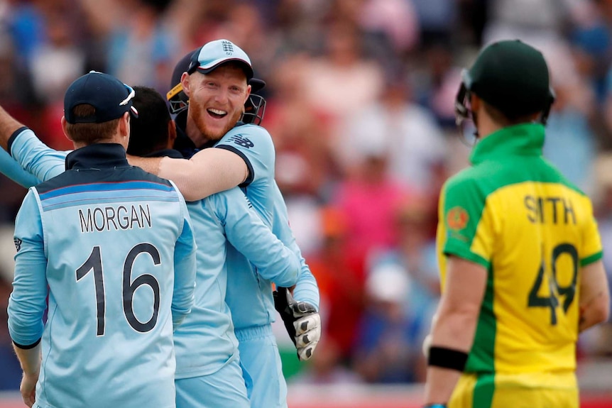 Steve Smith watches as England players Jason Roy and Eoin Morgan run to hug Adil Rashid, which Ben Stokes is already doing.