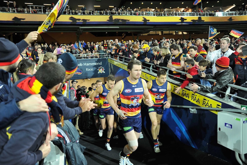 The Adelaide Crows enter the field against Hawthorn
