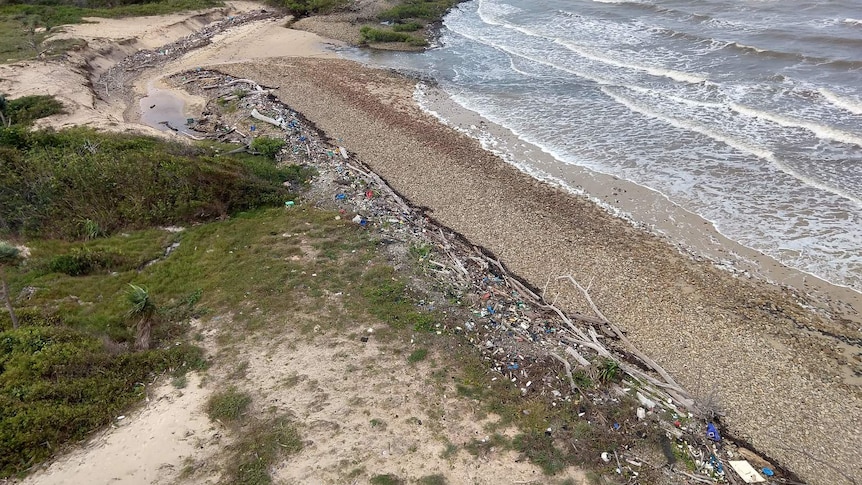 An aerial photo showing specks of marine waste washed up on a remote beach.