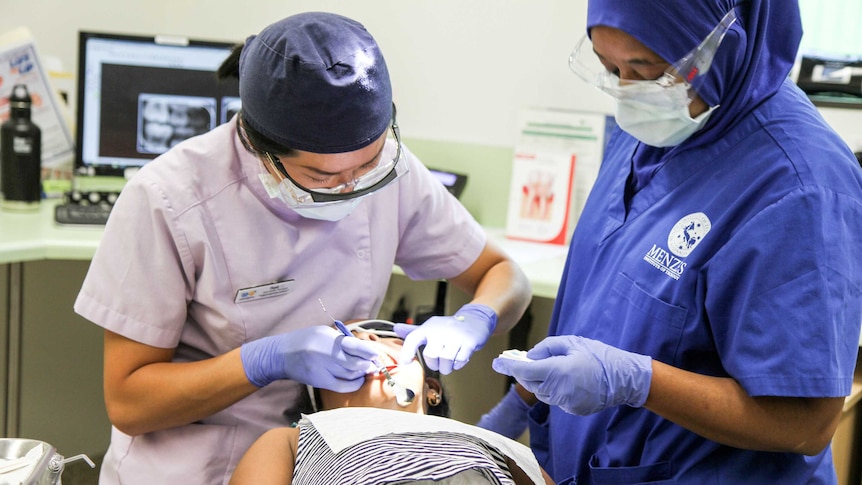 A dentist operates on a child.