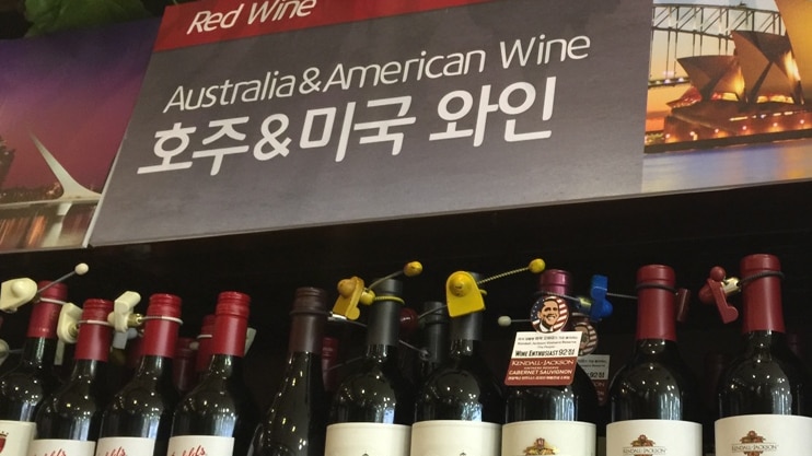 Bottles of Australian wine sit for sale on a shelf, with prices written in Korean
