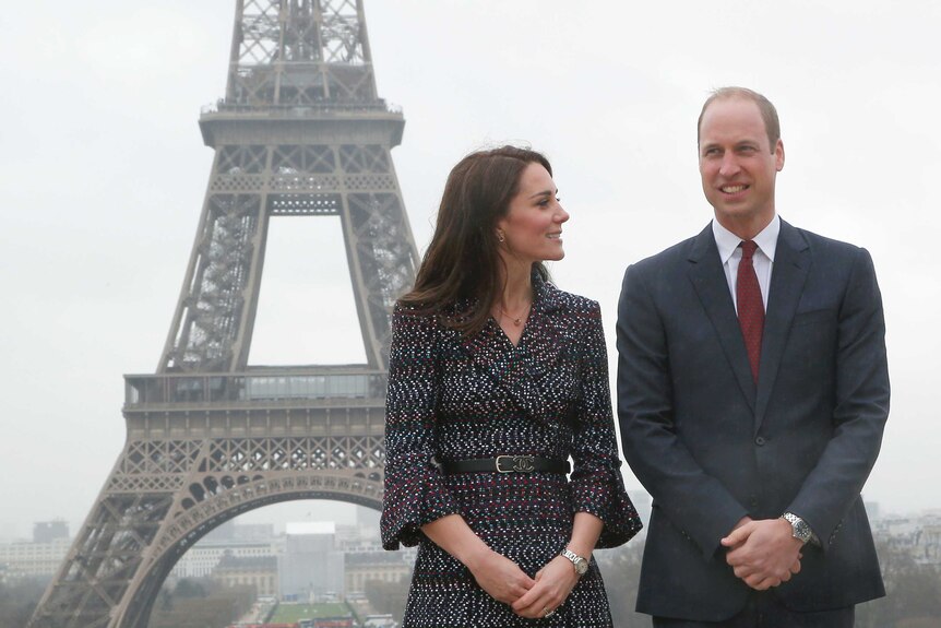 The Duke and Duchess of Cambridge pose for photographers with the Eiffel tower in background.