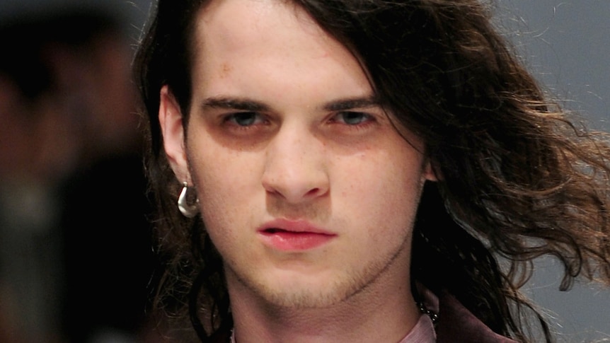 A young male model, Jethro Lazenby, son of Nick Cave, walks down a runway