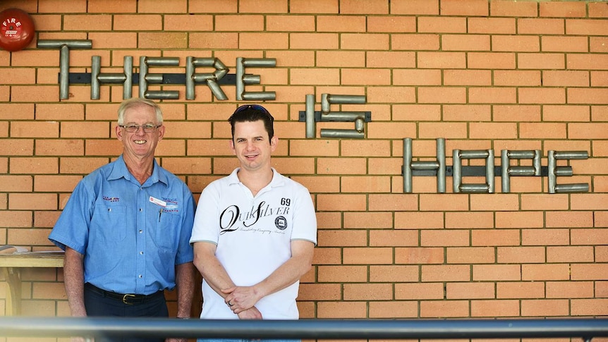 Leon Gordon and Nick Stoneman stand outside the Moonyah Recovery Centre with the sign 'There is Hope' in Brisbane.