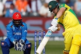 Aaron Finch drives hard through the covers while the wicketkeeper watches on.