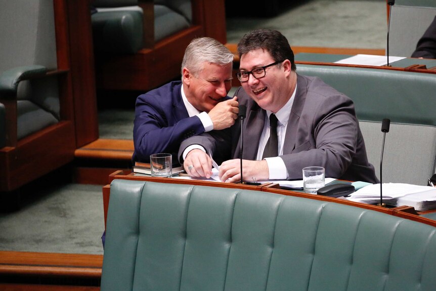 George Christensen and Michael Mccormack sit together laughing in the senate