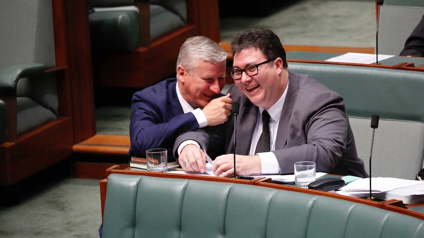 George Christensen and Michael Mccormack sit together laughing in the senate