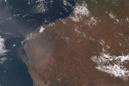 A satellite image of north-western Australia showing patchy cloud and a smokey haze.