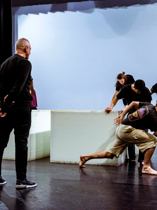 A man watches over three dancers