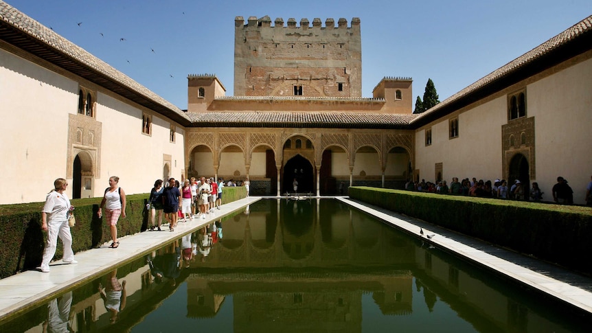 Visitors walk inside the Alhambra palace in Granada