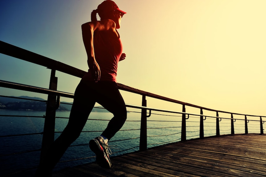 Woman jogging on a bridge by the water