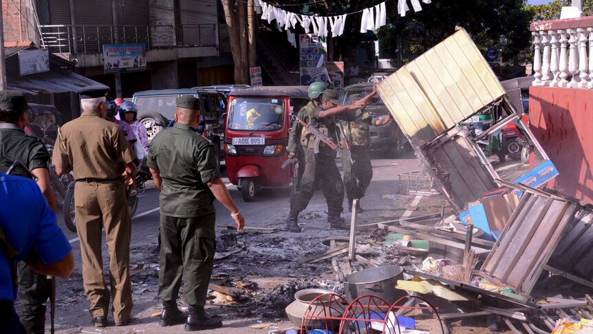 Sri Lanka's army soldiers remove the debris from a vandalized building